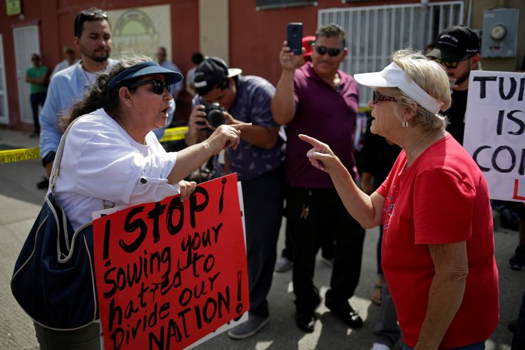 A pro-Trump demonstrator en een anti-Trump-demonstrant buiten het ziekenhuis in El Paso waar de Amerikaanse president een ontmoeting had met hulpverleners in El Paso.  Beeld REUTERS