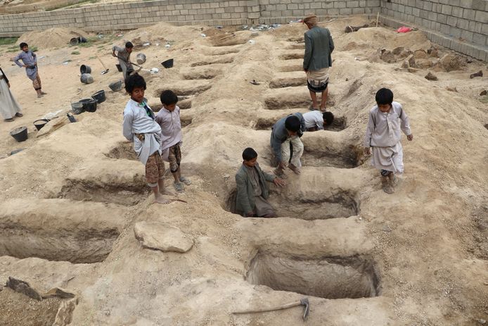 Jongens inspecteren de graven voor de slachtoffers van de luchtaanval in Jemen.