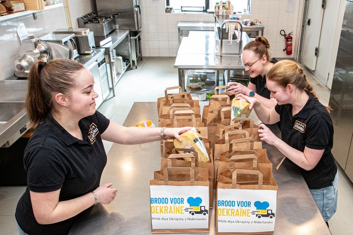 In De Sterkerij in Rijssen wordt brood voor Oekraïne verpakt. Vrijwilligers Noah, Malissa en Maureen (vlnr) hebben er lol in.