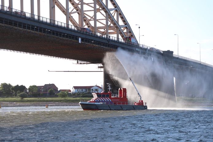 Met behulp van een blusboot probeert de brandweer het vuur onder controle te krijgen.