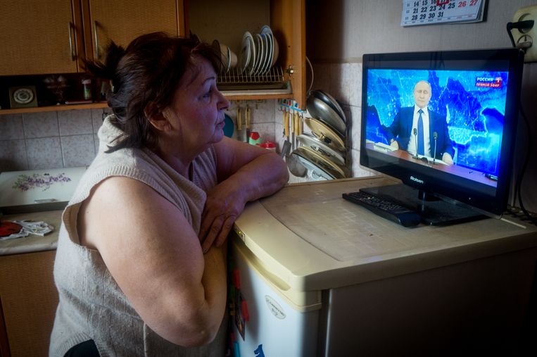 Een vrouw kijkt naar de jaarlijkse grote persconferentie van de Russische president Poetin. Beeld SOPA Images/LightRocket via Gett