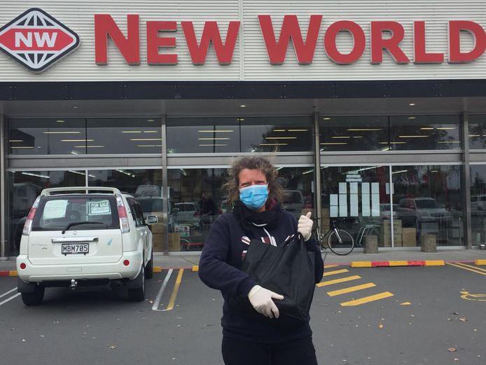 Fotografe Saskia Berdenis van Berlekom uit Amersfoort moet een mondkapje omdoen voordat ze een supermarkt ingaat in Kaiapoi, bij Christchurch.