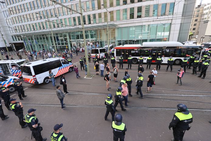 Gearresteerde mensen worden in bussen van de HTM naar een politiebureau gebracht.