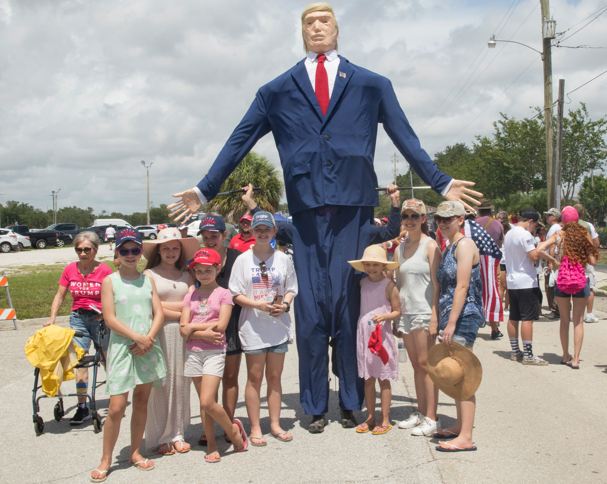 Een gezin poseert met een reusachtig model van Donald Trump voor een door Trump georganiseerde bijeenkomst in Sarasota, 3 juli 2021. 