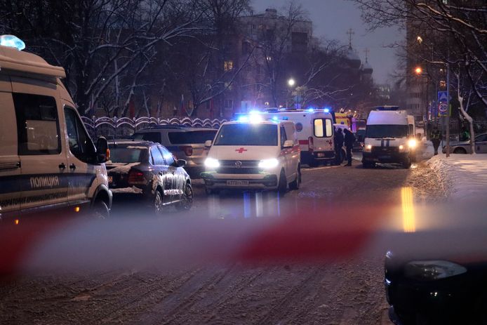 Politiewagens en ambulances voor het overheidsgebouw waar een man twee mensen doodschoot na een ruzie over het dragen van een mondkapje.