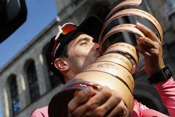 Tom Dumoulin kust in de roze leiderstrui de bokaal.