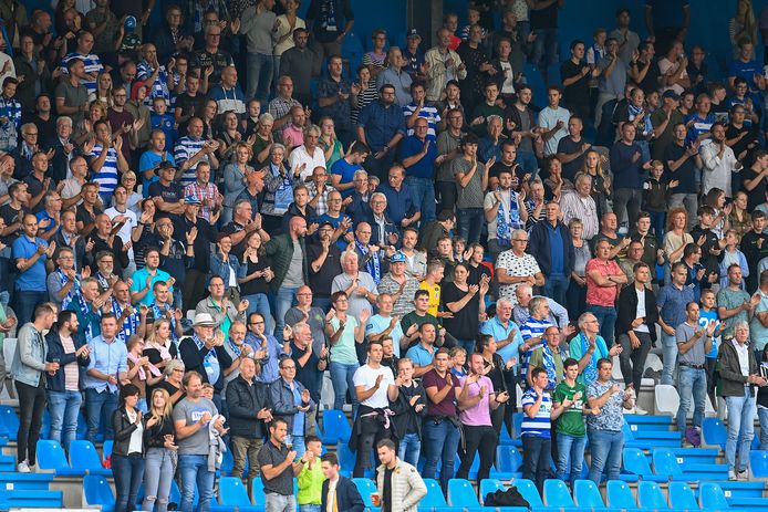 Supporters van De Graafschap moedigen hun club aan, staand op een zittribune op De Vijverberg.