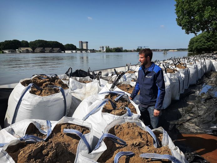 Ivo van Enckevort, inspecteur van Waterschap Limburg, bekijkt de situatie aan de kade in Well. Daar zijn een demontabele kering en big bags met zand geplaatst.