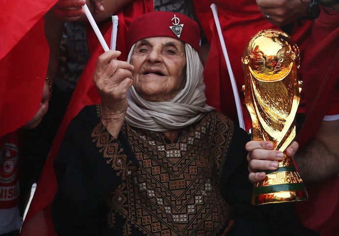 Een fan van Tunesië poseert met een replica van de  WK-trofee.