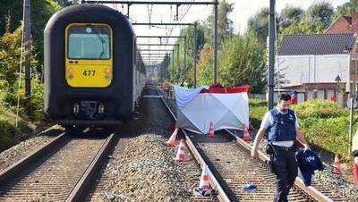 Telefonerende man gegrepen door trein voor ogen zoon
