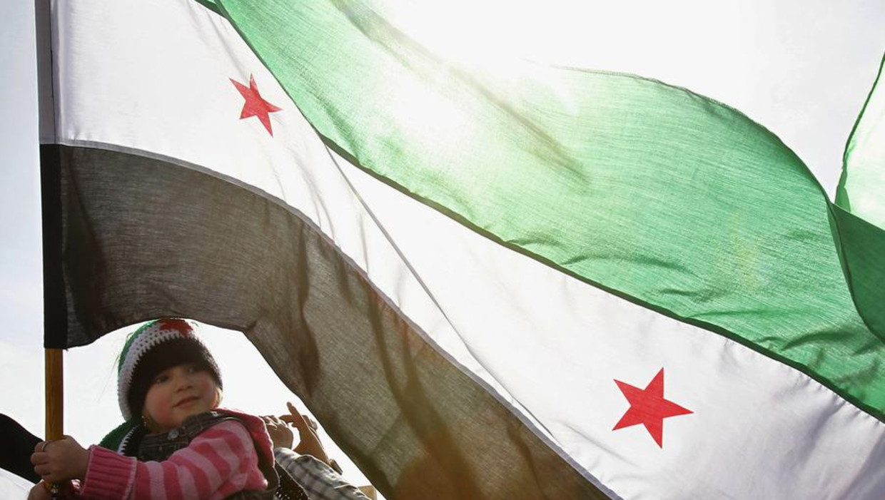 Een meisje in Syrië met de vlag van de Syrische oppositie Beeld reuters