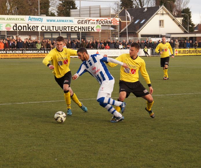 Willem Tieben (links) in april 2015 namens UNA in duel met Youssef El Jebli van FC Lienden. Rechts Jeroen Stottelaar.