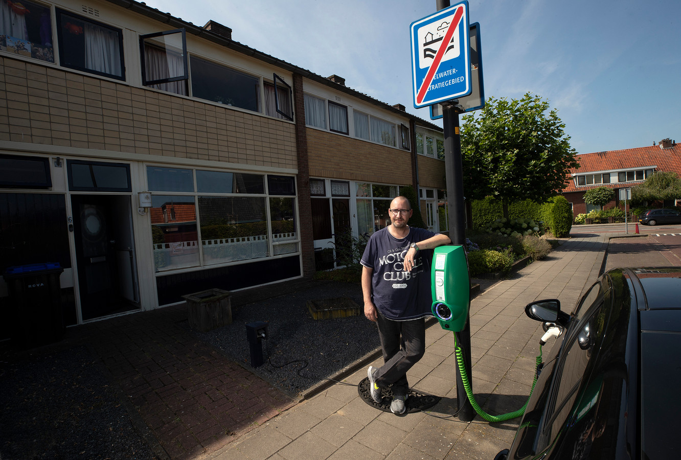 Jeroen van der Kaa met zijn zelfgemaakte laadpunt aan de lantaarnpaal. Hij ligt met de gemeente overhoop omdat hij zijn hybride niet voor zijn woning mag laden.