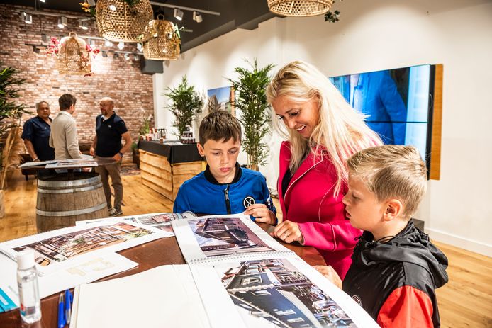 Imelda, Liam en Dean (r) bladeren door de nieuwbouwplannen voor winkelcentrum Aarhof die in het informatiecentrum zijn in te zien.