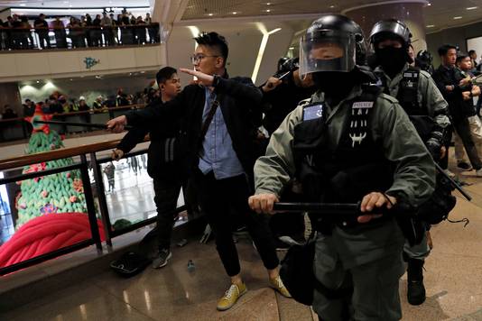 Oproerpolitie in Hongkong jaagt demonstranten uiteen in een winkelcentrum.