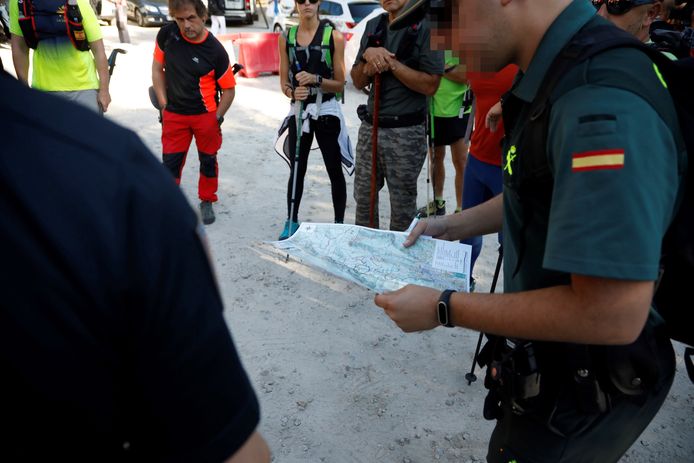 Een lid van de Guardia Civil haalt een stafkaart boven en geeft instructies aan vrijwilligers.