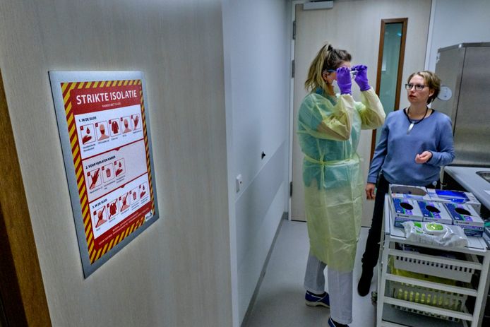 Verpleegkundige doet beschermende kleding aan in een sluis van een van de isolatiekamers van het Albert Schweitzer ziekenhuis in Dordrecht.