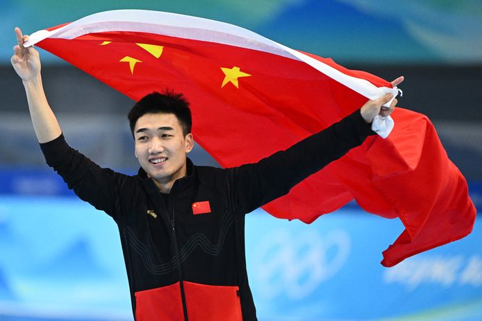Gao Tingyu met de Chinese vlag nadat hij goud heeft gewonnen op de 500 meter.