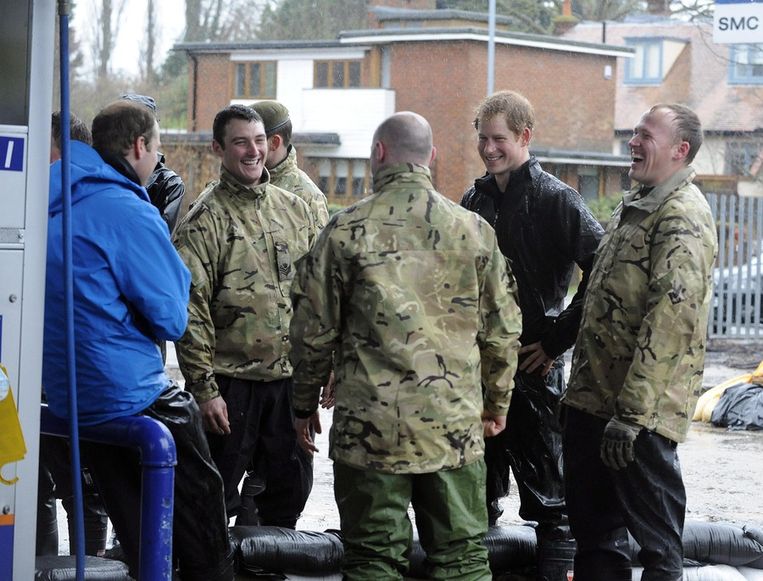 Prins William (L) en prins Harry helpen militairen bij de overstromingen. Beeld anp