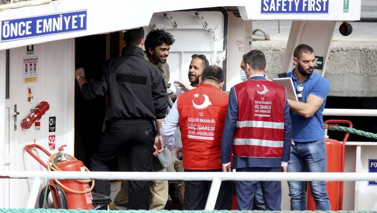 Een migrant verlaat onder escorte de boot waarmee hij naar Turkije is teruggebracht. Beeld reuters
