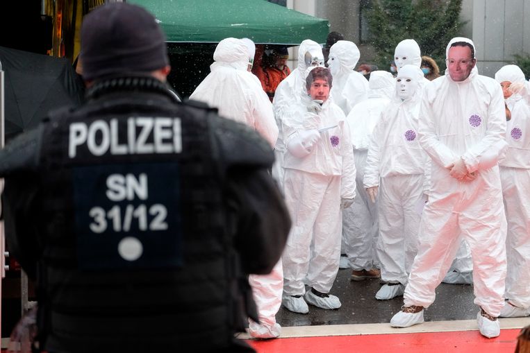 Demonstranten protesteren tegen het Duitse coronabeleid in beschermende pakken en maskers op met de beeltenis van viroloog Christian Drosten en Volksgezondheidsminister Spahn.  Beeld AP