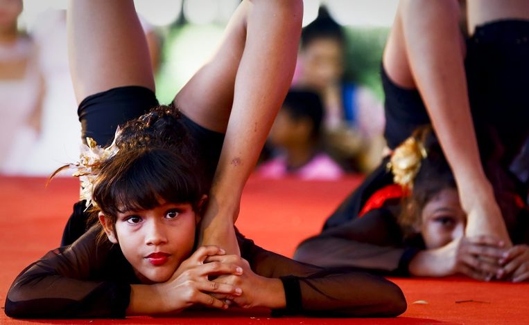 Ook buiten India wordt de internationale dag van de yoga gevierd. In Bangkok wurmt een kind zich schijnbaar moeiteloos in deze yogapose. Beeld EPA