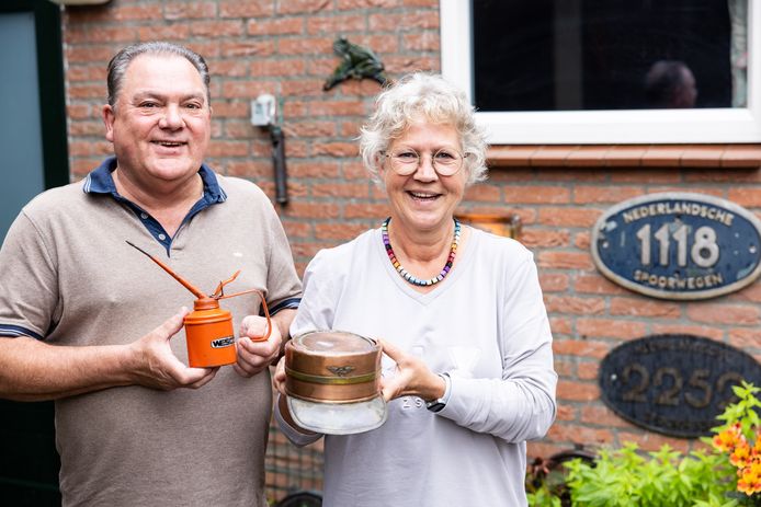 Joop Joosen en Monique Vos tonen twee bijzondere NS-attributen: een oud oliespuitje zoals de monteurs dat gebruikten en een  koperen conducteurspet, door collega's gemaakt voor een jubileum.