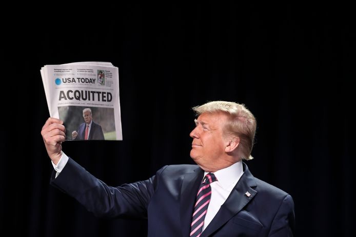 Trump met een exemplaar van de krant USA Today met 'VRIJGESPROKEN' in blokletters.
