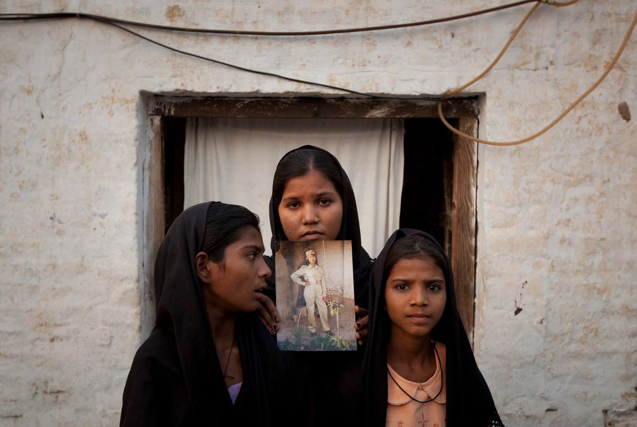 De dochters van Asia Bibi tonen een foto van hun moeder, kort na haar eerste terdoodveroordeling in 2010. Beeld REUTERS