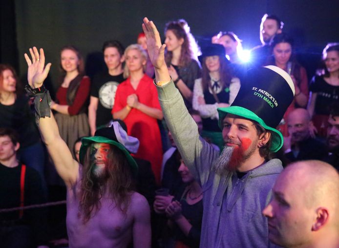 Mannen steken hun hand omhoog tijdens een St. Patrick's Day-feestje in Minsk, in Wit-Rusland.