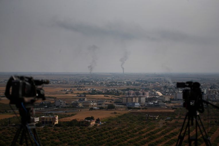 Rook kringelt op boven de grensstad Ras al-Ain. Deze foto is genomen vanaf de Turkse kant van de grens. Beeld AP