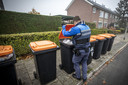 Een boa controleert afval in een vuilcontainer in Oldenzaal.