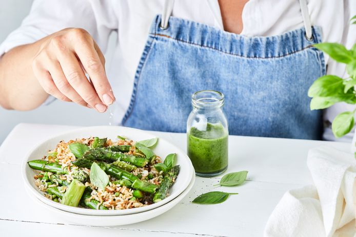 Gebakken rijst met groene asperges, erwtjes en basilicumolie