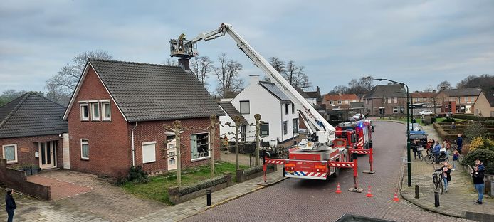De brandweer bestrijdt de schoorsteenbrand in de Kerkstraat in Heesch.