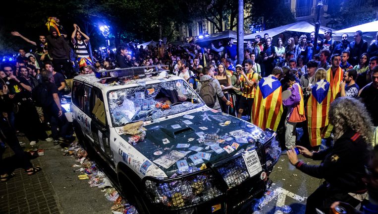 Betogers tegen de Spaanse regering hebben een auto van de Guardia Civil beplakt tijdens protesten in de nacht van woensdag op donderdag in Barcelona. Beeld epa