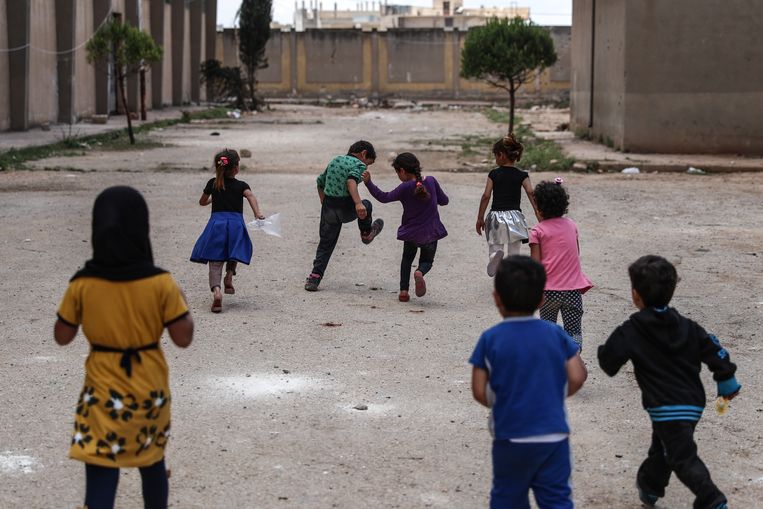 Kinderen spelen op de speelplaats van een school in Ghouta, die gebruikt wordt voor ontheemden.  Beeld EPA