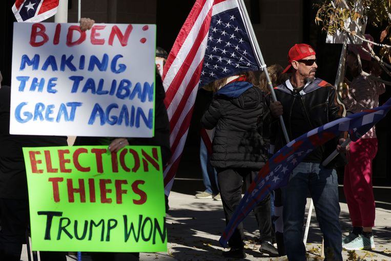 Supporters van Donald Trump protesteren buiten het Smith Center for the Performing Arts tijdens de herdenkingsdienst voor de voormalige senator Harry Reid, 8 januari in Las Vegas, Nevada.  Beeld AFP
