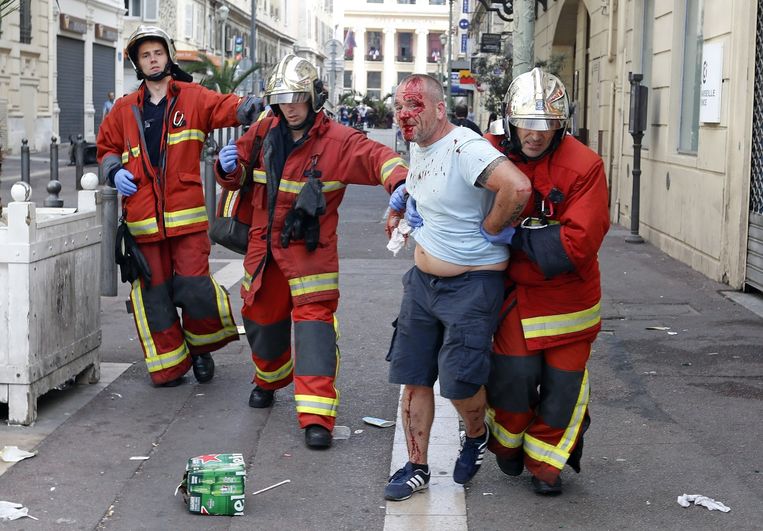 Een gewonde man wordt weggeleid door de hulpdiensten in Marseille. Beeld ap
