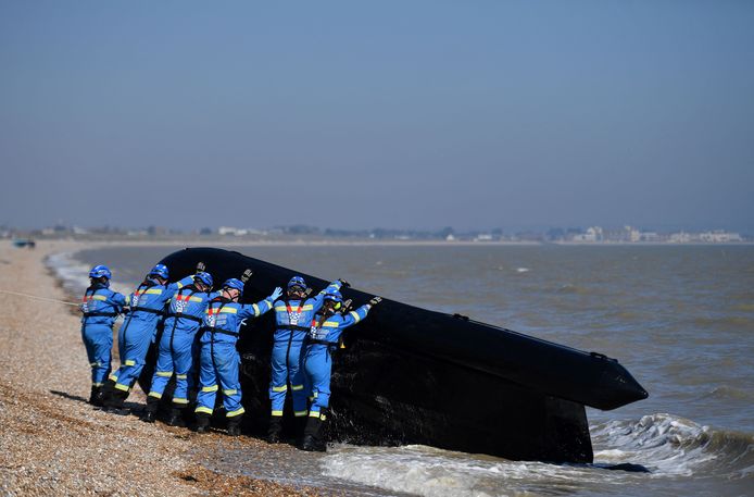 Leden van de kustwacht in Engeland halen een boot uit het water waarmee migranten het Kanaal van Frankrijk naar Engeland probeerden over te steken.