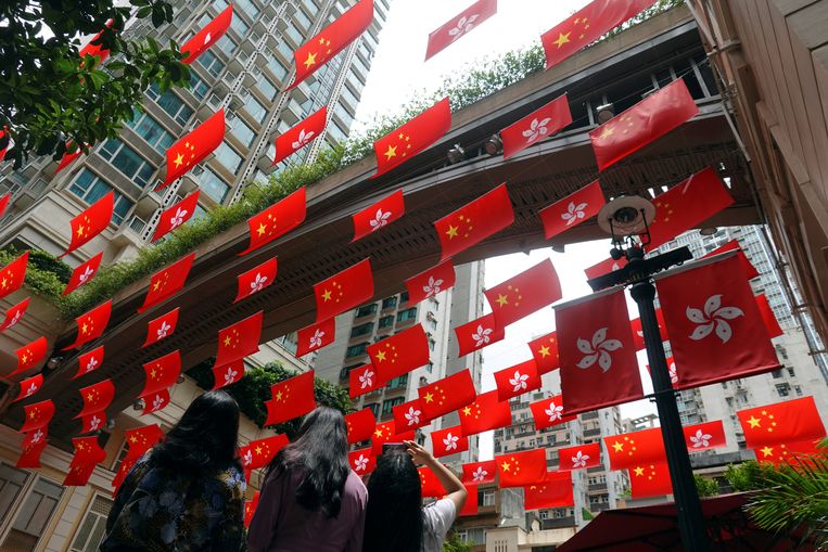 Een straat in Hongkong is versierd met vlaggen van de stad en van China. Beeld Reuters