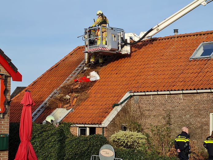 De brandweer licht een groot deel van het dak op om het vuur te blussen.
