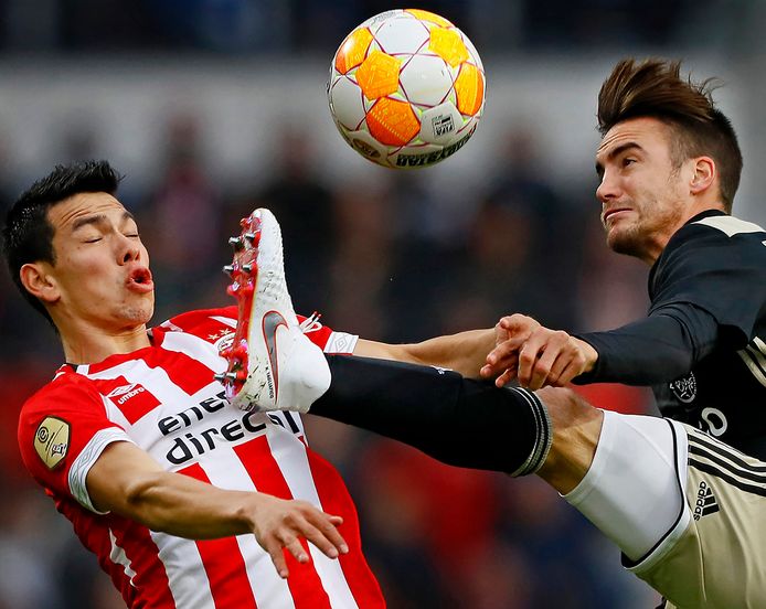 Beeld uit het duel tussen PSV en Ajax (3-0) eerder dit seizoen: Hirving Lozano schrikt van het hooggeheven been van Nicolas Tagliafico