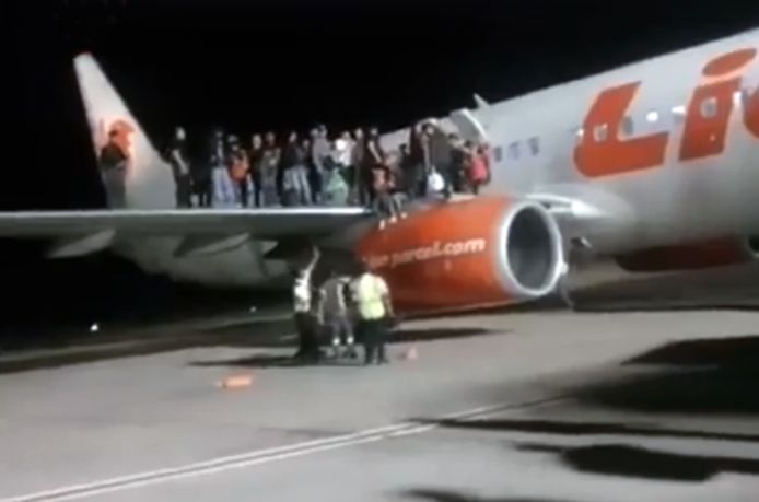 Op videobeelden is te zien hoe tientallen passagiers op de vleugel van de Boeing staan.