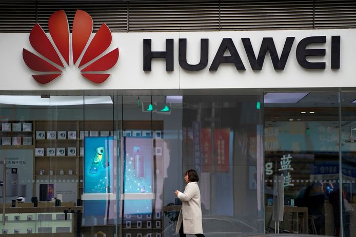 Een vrouw wandelt voorbij een winkel van Huawei in Shanghai.