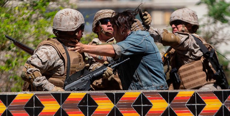 Chileense soldaten houden een demonstrant vast bij gewelddadige rellen in Santiago.  Beeld AFP