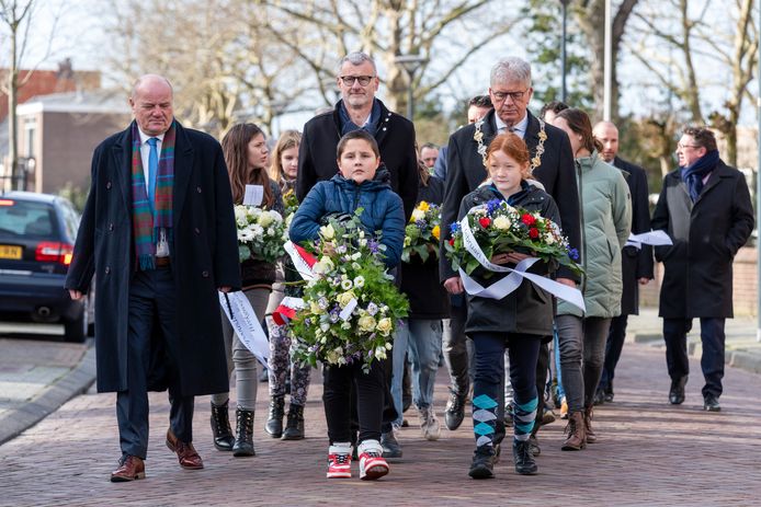 Vanaf de kerk in Lepelstraat loopt het gezelschap met onder anderen burgemeester Frank Petter, wethouder Hans Peter Verroen en de Steenbergse locoburgemeester Maurice Remery  (helemaal links) naar de begraafplaats om daar bloemen te leggen.