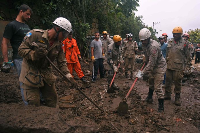 Firefighters and volunteers are seen during a rescue mission after a giant landslide at Caxumbu neighborhood in Petropolis, Brazil, on February 19, 2022. - A total of 136 bodies have been retrieved to date, according to civil defense officials, in the normally scenic tourist town some 60 kilometers (37 miles) north of Rio de Janeiro. (Photo by MAURO PIMENTEL / AFP)