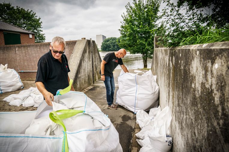 Jan Wilmer (zonnebril) en Luuc Driessen van Kanovereniging Viking Venlo zijn bezig om de waterschotten en zandzakken op te ruimen nadat het water van de Maas weer is gezakt.
 Beeld Maikel Samuels