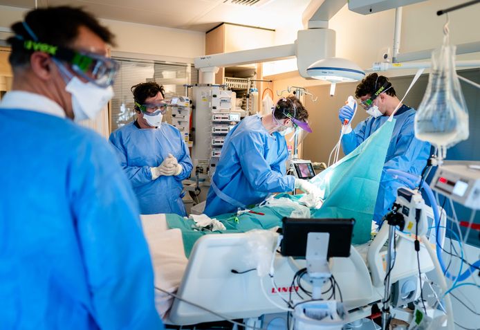 Medewerkers leggen een tracheotomie zodat de patiënt kunstmatig beademd kan worden op de speciale Covid-IC afdeling .