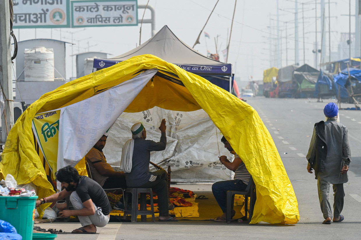 Protesterende boeren rusten in een tent langs de snelweg, waar ze protesteren tegen de landbouwhervormingen van de regering.  Beeld AFP
